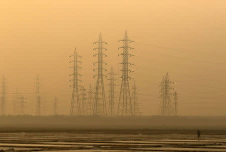 FILE PHOTO: A worker levels a salt pan near electricity pylons in Mumbai, India, January 16, 2017. REUTERS/Shailesh Andrade/File Photo
