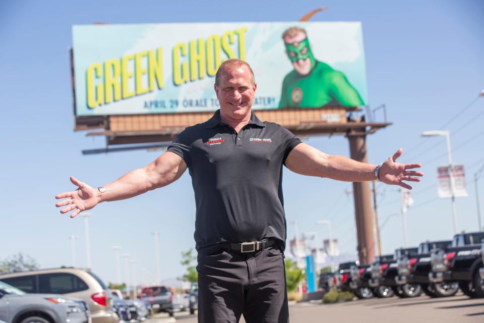 Charlie Clark is photographed with his movie promotion billboard at his car dealership in April in El Paso.