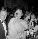 <p>Marilyn Monroe wearing a champagne-hued gown and matching fur stole. </p>