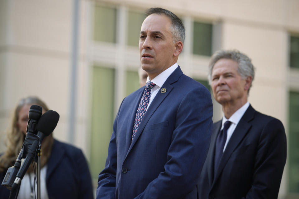 Mark Michalek, front, special agent in charge of the FBI's bureau in Denver, speaks as U.S. Attorney for Colorado, Cole Finegan, back, looks on after a judge handed down a sentence of life in prison and more than $15 million in penalties to Larry Rudolph, the wealthy owner of a Pittsburgh-area dental franchise, for killing his wife at the end of an African safari in Zambia, during a sentencing hearing Monday, Aug. 21, 2023, in the federal courthouse in Denver. (AP Photo/David Zalubowski)