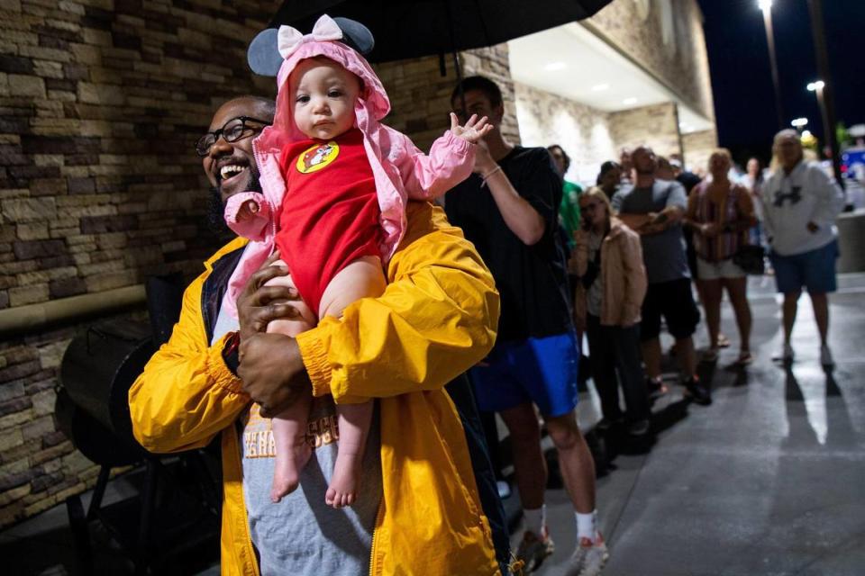 Jonathan Curry cheers as he holds up his daughter Olivia Curry while waiting in line for the grand opening of Buc-ee’s in Sevierville on June 26.