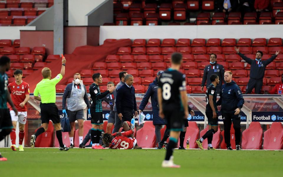 Swansea City's Kyle Naughton (second right) receives a red card from referee Oliver Langford during the Sky Bet Championship match at the City Ground, Nottingham - PA