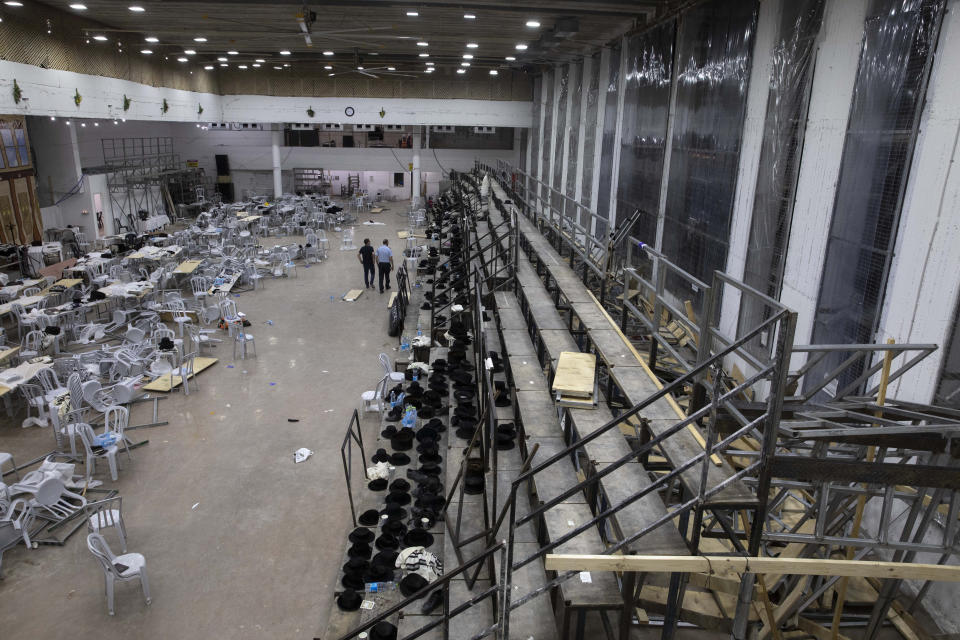 Israeli police officers walk inside an empty synagogue is seen in Givat Zeev, outside Jerusalem, Sunday, May 16, 2021. Israeli medics say more than 150 people were injured in a fatal collapse of a bleacher at an uncompleted West Bank synagogue. (AP Photo/Sebastian Scheiner)