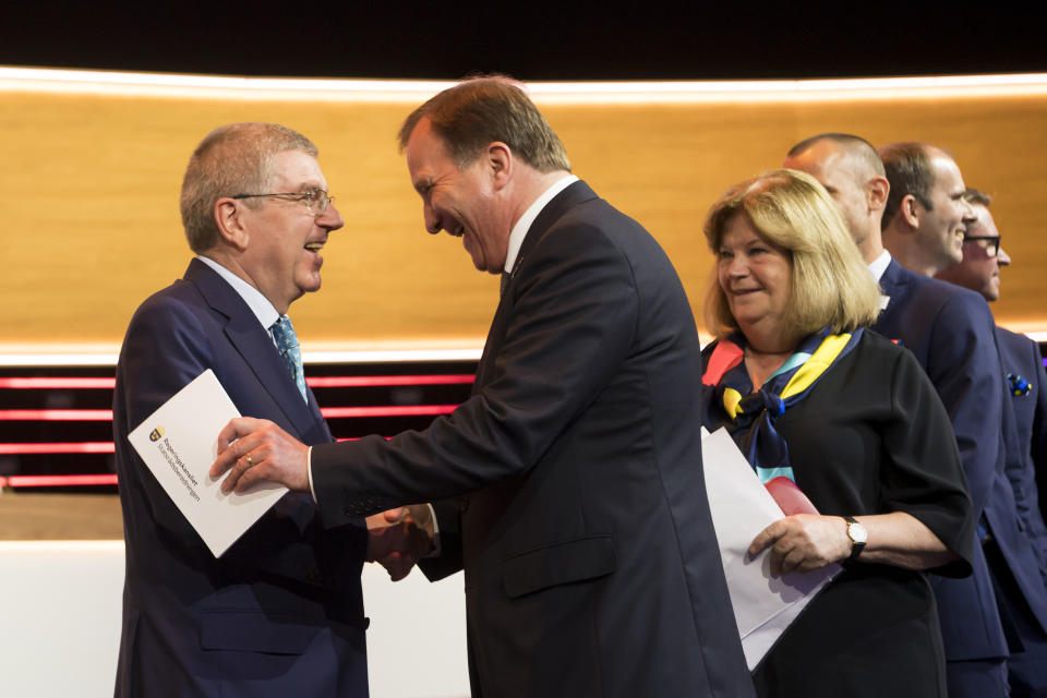 FILE - International Olympic Committee, IOC, President Thomas Bach from Germany, shakes hands with Swedish Prime Minister Stefan Lofven during the first day of the 134th Session of the International Olympic Committee (IOC), at the SwissTech Convention Centre, in Lausanne, on June 24, 2019. For an ailing search for a 2030 Olympics host now to have Sweden emerge as frontrunner is a surprise in Stockholm as elsewhere. (Jean-Christophe Bott/Keystone via AP, File)