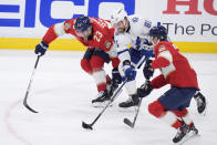 Florida Panthers centers Carter Verhaeghe (23) and Sam Reinhart, right, battle for the puck with Tampa Bay Lightning defenseman Erik Cernak (81) during the second period of Game 5 of the first-round of an NHL Stanley Cup Playoff series, Monday, April 29, 2024, in Sunrise, Fla. (AP Photo/Wilfredo Lee)