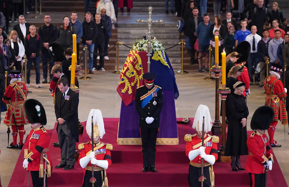 Queen Elizabeth II 's grandchildren (clockwise from front centre) Britain's Prince William, Prince of Wales, Peter Phillips, James, Viscount Severn, Britain's Princess Eugenie of York, Britain's Prince Harry, Duke of Sussex, Britain's Princess Beatrice of York, Britain's Lady Louise Windsor and Zara Tindall hold a vigil around the coffin of Queen Elizabeth II, draped in the Royal Standard with the Imperial State Crown and the Sovereign's orb and sceptre, lying in state on the catafalque in Westminster Hall, at the Palace of Westminster in London on September 17, 2022, ahead of her funeral on Monday. - Queen Elizabeth II will lie in state in Westminster Hall inside the Palace of Westminster, until 0530 GMT on September 19, a few hours before her funeral, with huge queues expected to file past her coffin to pay their respects. (Photo by Yui Mok / POOL / AFP) (Photo by YUI MOK/POOL/AFP via Getty Images)