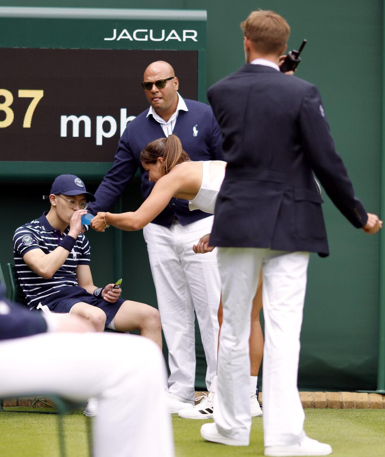 Jodie Burrage helps a ball boy after they fainted during her Ladies' singles first round match against Lesia Tsurenko during day one of the 2022 Wimbledon Championships at the All England Lawn Tennis and Croquet Club, Wimbledon. Picture date: Monday June 27, 2022.