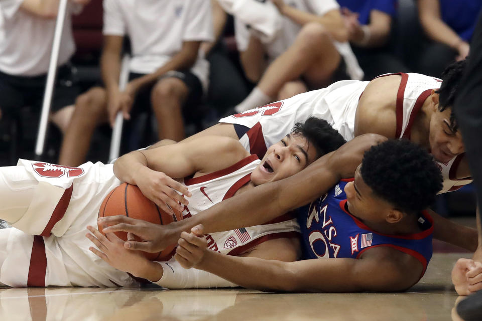 Stanford guard Tyrell Terry, bottom left, tries to control the ball under teammate Spencer Jones, top, and Kansas guard Ochai Agbaji during the first half of an NCAA college basketball game in Stanford, Calif., Sunday, Dec. 29, 2019. (AP Photo/Jeff Chiu)