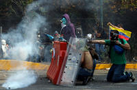 Manifestantes lanzan piedras con hondas en contra de los agentes antimotines en una protesta antigubernamental en Caracas, Venezuela, el miércoles 12 de marzo de 2014. (AP Photo/Fernando Llano)