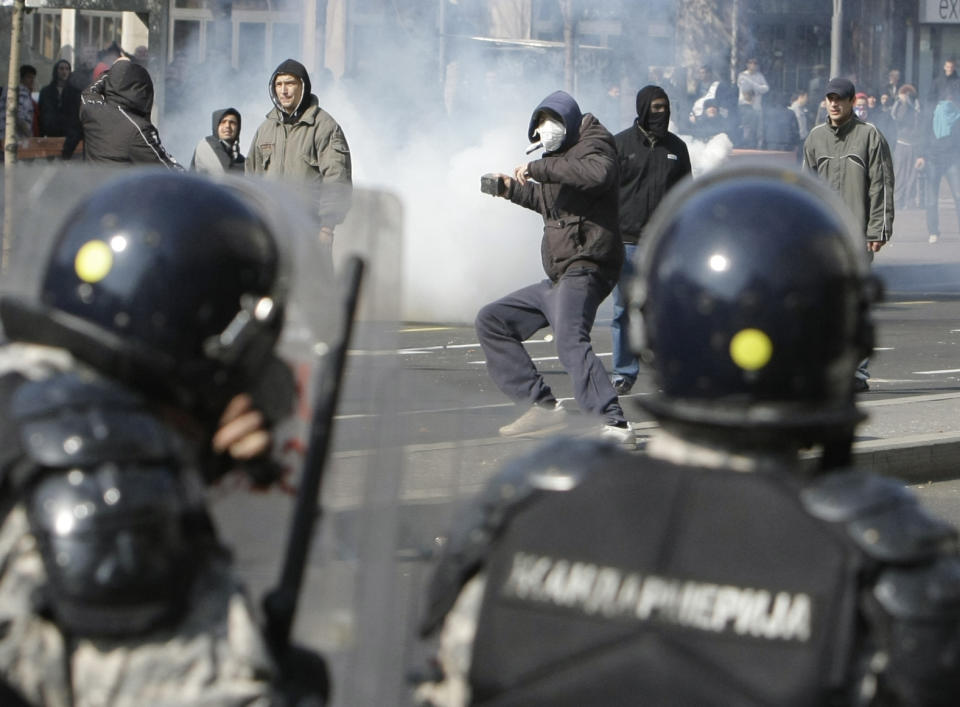 FILE - Protesters throw stones at the members of the riot police during an anti gay pride march in Belgrade, Serbia, Sunday, Oct. 10, 2010. Organizers of a pan-European LGBTQ events held in Belgrade this week said Friday they will hold a planned Pride march in the Serbian capital despite a police ban and threats from ani-gay groups. Serbia's police have banned the parade that is planned for Saturday, citing a risk of clashes with far-right activists who also said they will gather in protest. Several legal appeals against the ban launched by the Pride week organizers have been rejected by Serbia's authorities. (AP Photo/Darko Vojinovic, File)