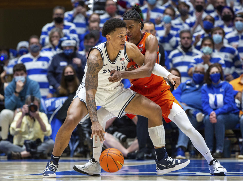 Duke's Paolo Banchero, left, handles the ball while Virginia Tech's David N'Guessan, right, defends during the first half of an NCAA college basketball game in Durham, N.C., Wednesday, Dec. 22, 2021. (AP Photo/Ben McKeown)