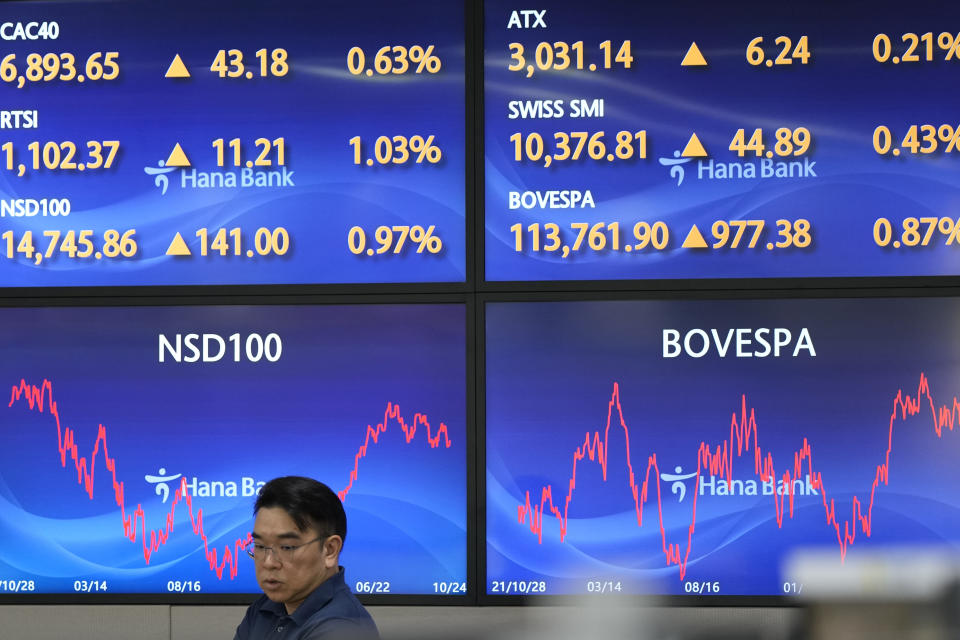 A currency trader walks by the screens at a foreign exchange dealing room in Seoul, South Korea, Wednesday, Oct. 25, 2023. Asian shares advanced Wednesday, tracking gains on Wall Street after Verizon and other big companies reported fatter profits for the summer than expected. (AP Photo/Lee Jin-man)