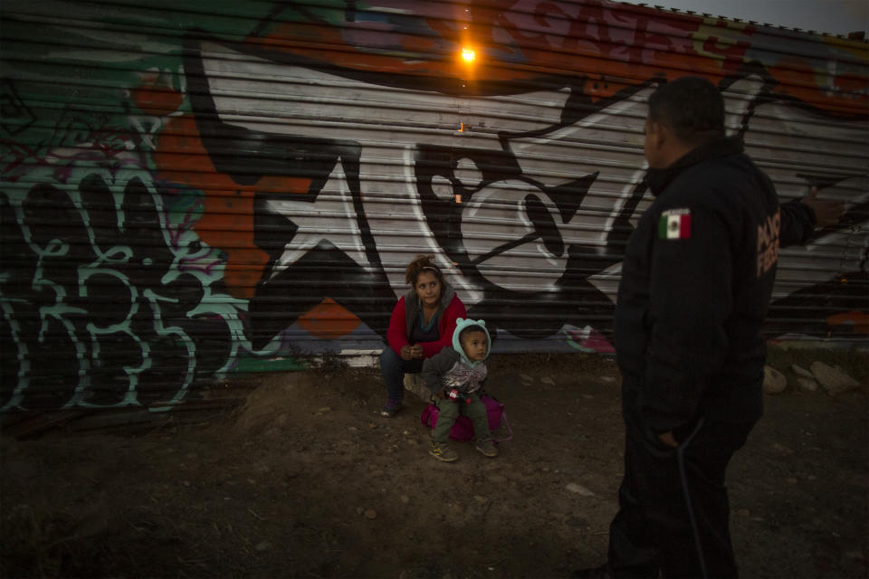 Xinia (19) and her son Kevin (4) talk with Mexican border police after being caught crossing the Mexico-US border wall, December 1, 2018. (Photo: Fabio Bucciarelli for Yahoo News)