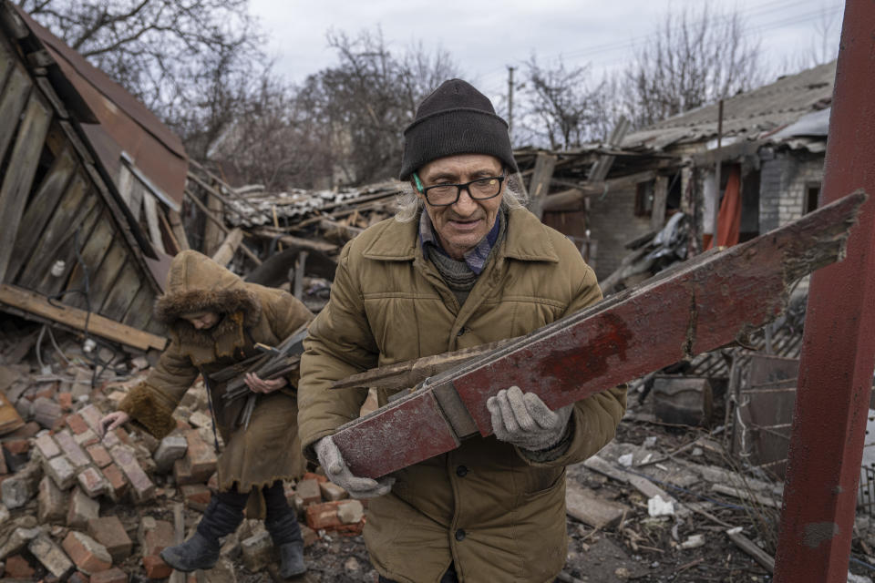 Hennadiy Mazepa and his wife Natalia Ishkova collect wood from a house which was destroyed by Russian forces in Chasiv Yar, Ukraine, Friday, March 3, 2023. (AP Photo/Evgeniy Maloletka)