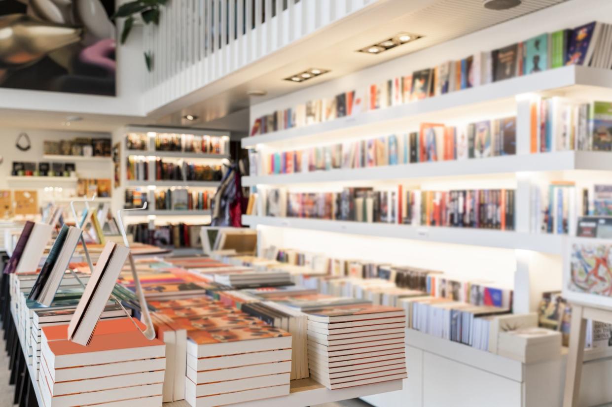 Very modern and bright bookstore with white shelves full of books seen during day light.