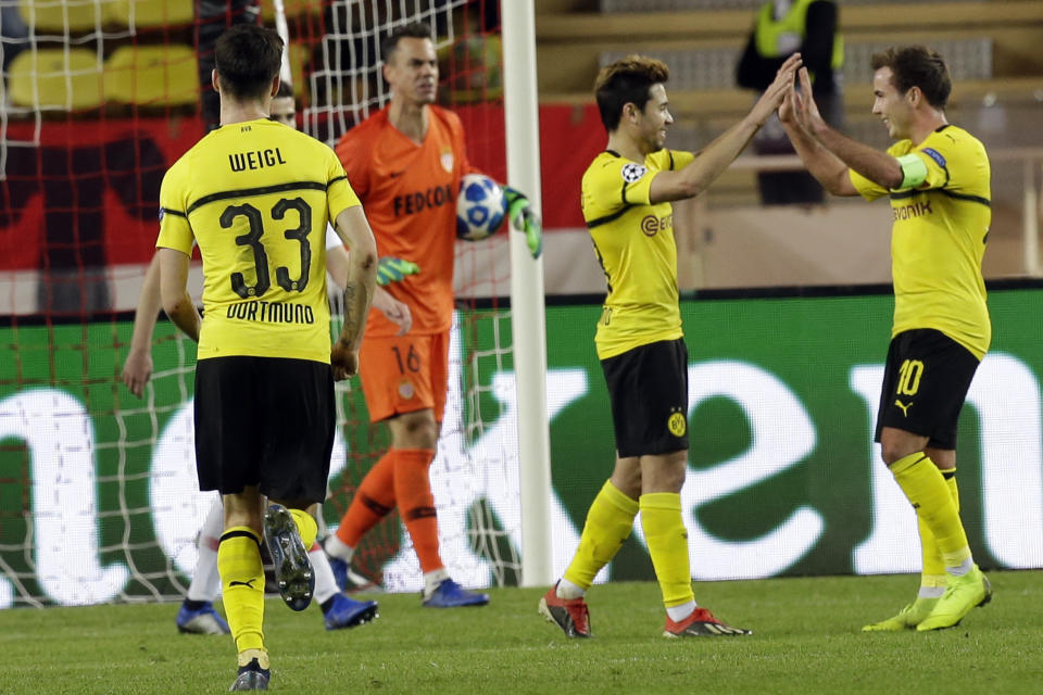 Dortmund's Raphael Guerreiro, second right, celebrates with teammate Mario Gotze, right, after scoring his side second goal during the Champions League group A soccer match between AS Monaco and Borussia Dortmund, in Monaco, Tuesday, Dec. 11, 2018. (AP Photo/Claude Paris)