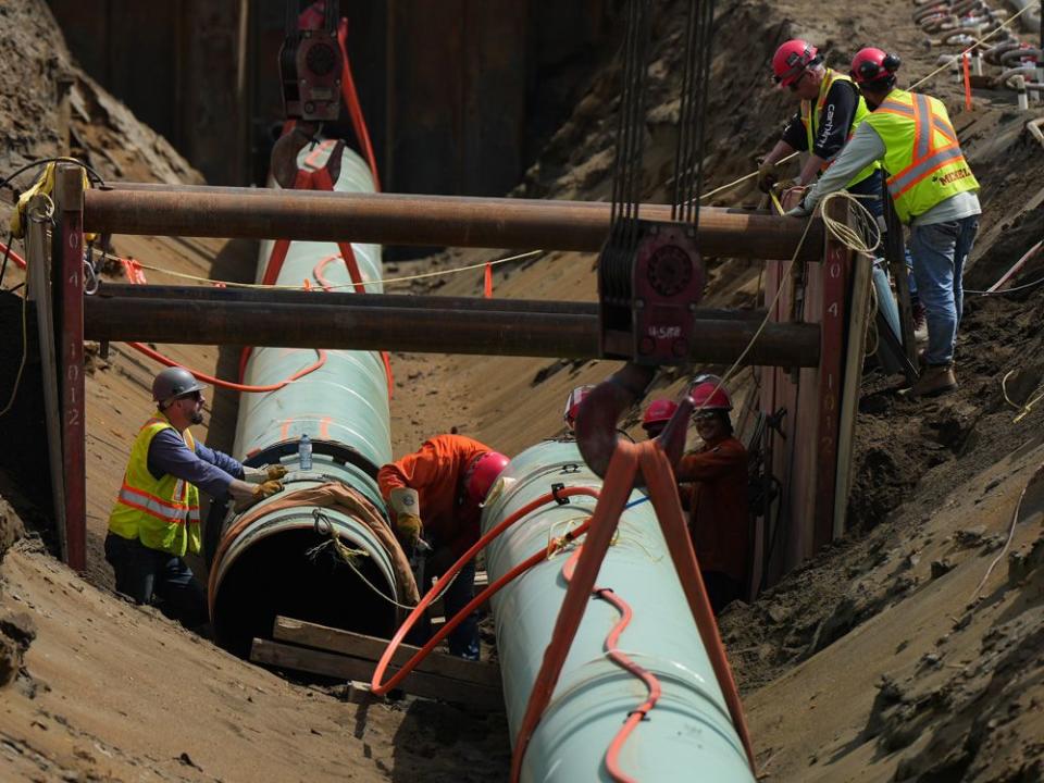  Workers place pipes during construction of the Trans Mountain pipeline expansion on farmland in Abbotsford, B.C.