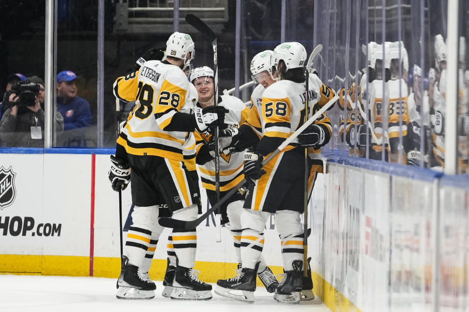 Pittsburgh Penguins' Jake Guentzel, center, celebrates with teammates after scoring a goal against the New York Islanders during the second period of an NHL hockey game Wednesday, Dec. 27, 2023, in Elmont, N.Y. (AP Photo/Frank Franklin II)