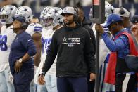 Dallas Cowboys quarterback Dak Prescott, center, watches play in the second half of a NFL football game against the Washington Commanders in Arlington, Texas, Sunday, Oct. 2, 2022. (AP Photo/Ron Jenkins)