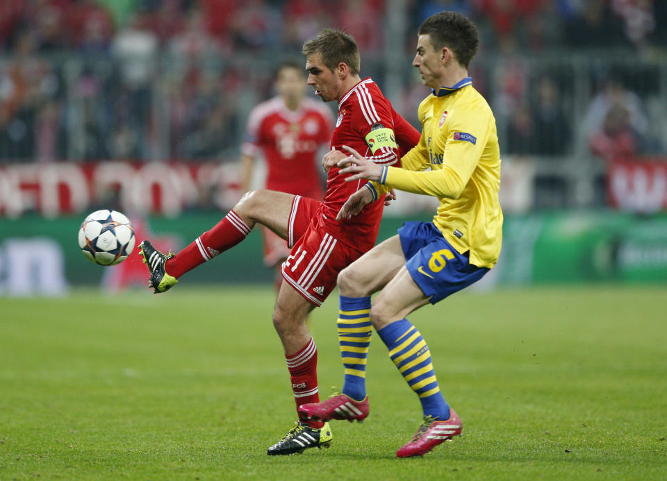 Bayern's Philipp Lahm, left, is challenged by Arsenal's Laurent Koscielny during the Champions League round of 16 second leg soccer match between FC Bayern Munich and FC Arsenal in Munich, Germany, Wednesday, March 12, 2014. (AP Photo/Matthias Schrader)