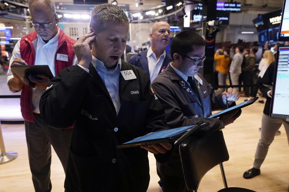 Craig Esposito, foreground left, works with fellow traders on the floor of the New York Stock Exchange, Wednesday, Aug. 7, 2024. (AP Photo/Richard Drew)