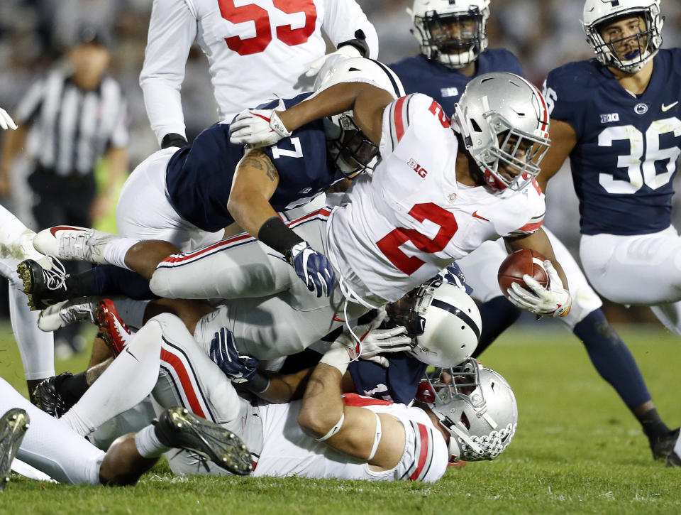 Ohio State's J.K. Dobbins (2) is tackled by Penn State's Koa Farmer (7) during the first half of an NCAA college football game in State College, Pa., Saturday, Sept. 29, 2018. (AP Photo/Chris Knight)