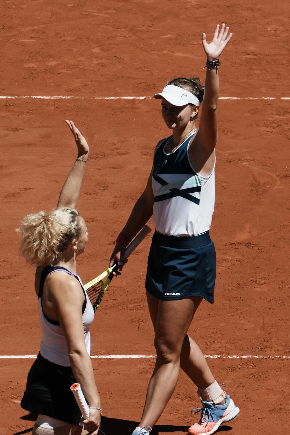 Czech Republic's Barbora Krejcikova, right, and compatriot Katerina Siniakova wave after they defeating USA's Bethanie Mattek-Sands and Poland's Iga Swiatek during their women's doubles final match of the French Open tennis tournament at the Roland Garros stadium Sunday, June 13, 2021 in Paris. (AP Photo/Thibault Camus)