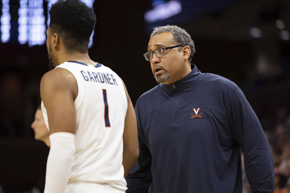 Virginia associate head coach Jason Williford speaks to Jayden Gardner (1) during the first half of an NCAA college basketball game against Louisville in Charlottesville, Va., Saturday, March 4, 2023. (AP Photo/Mike Kropf)