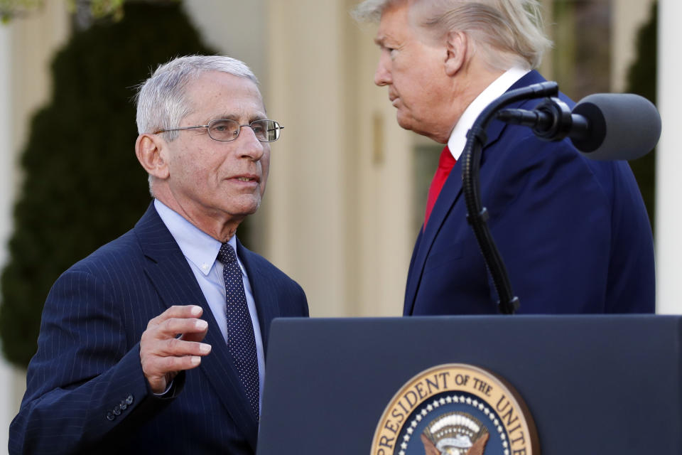 Dr. Anthony Fauci, director of the National Institute of Allergy and Infectious Diseases, takes the podium to speaks about the coronavirus in the Rose Garden of the White House, Monday, March 30, 2020, in Washington, as President Donald Trump listens. (AP Photo/Alex Brandon)