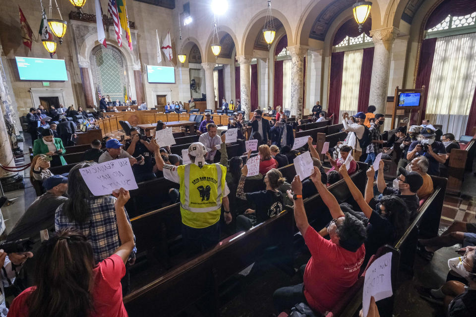 People hold signs and shout slogans as they protest before the cancellation of the Los Angeles City Council meeting Wednesday, Oct. 12, 2022 in Los Angeles. (AP Photo/Ringo H.W. Chiu)