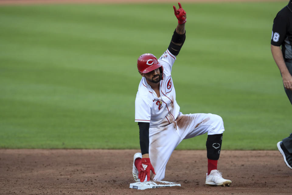 Cincinnati Reds' Nicholas Castellanos (2) reacts to teammates after hitting a double in the third inning during a baseball game against the Detroit Tigers at Great American Ballpark in Cincinnati, Friday, July 24, 2020. (AP Photo/Aaron Doster)