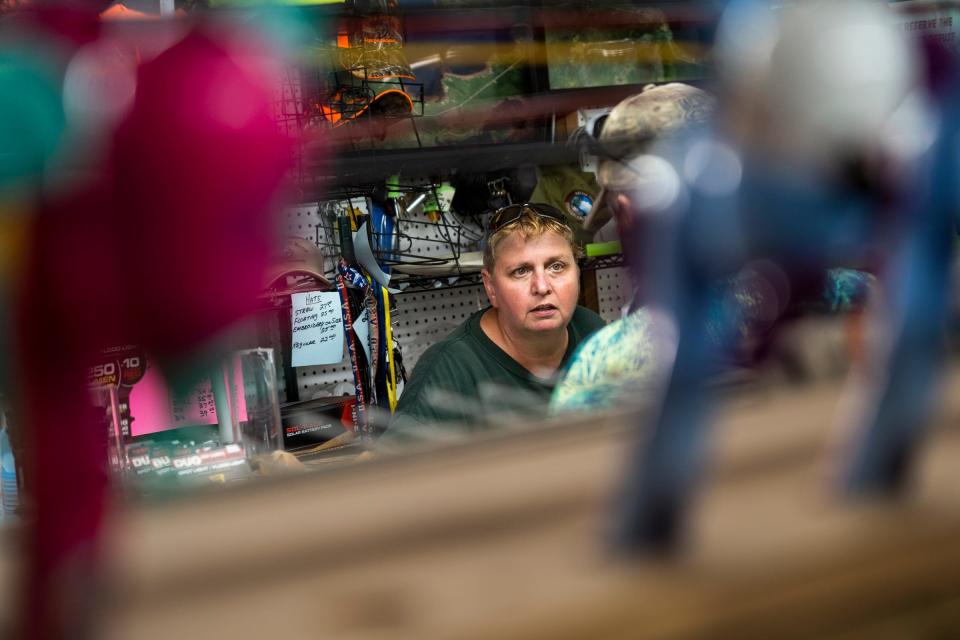 Mick's Bait Shop owner Mick Treiber, 56, helps a customer stopping in her store on Tuesday, July 25, 2023.