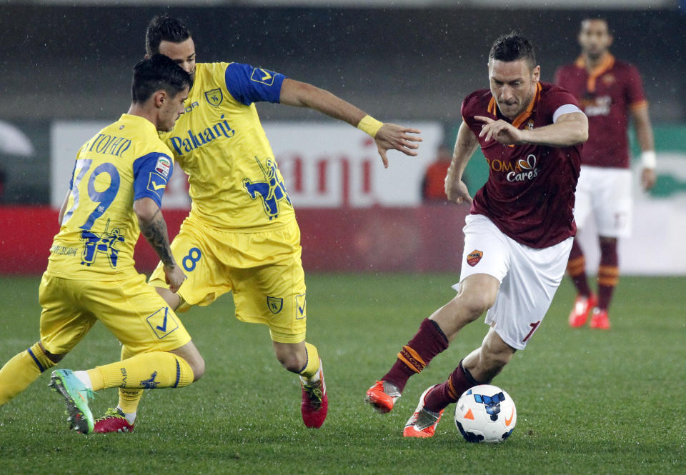 AS Roma's Francesco Totti, right, is chased by Chievo's Adrian Stoian, left, of Romania, and teammate Ivan Radovanovic, of Serbia, during a Serie A soccer match at Bentegodi stadium in Verona, Italy, Saturday, March 22, 2014. (AP Photo/Felice Calabro')