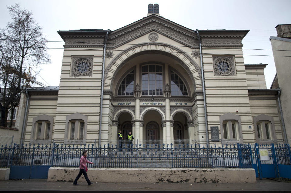 In this photo taken on Wednesday, Oct. 31, 2018, a woman walks past a synagogue in Vilnius, Lithuania. Jewish leaders in the Lithuanian capital are closing the city’s sole synagogue and community center indefinitely following a string of threats sparked by an emotional debate over history. Community leader Faina Kukliansky told The Associated Press on Wednesday, Aug. 7, 2019 that “our community is receiving threatening calls and letters lately. (AP Photo/Mindaugas Kulbis)