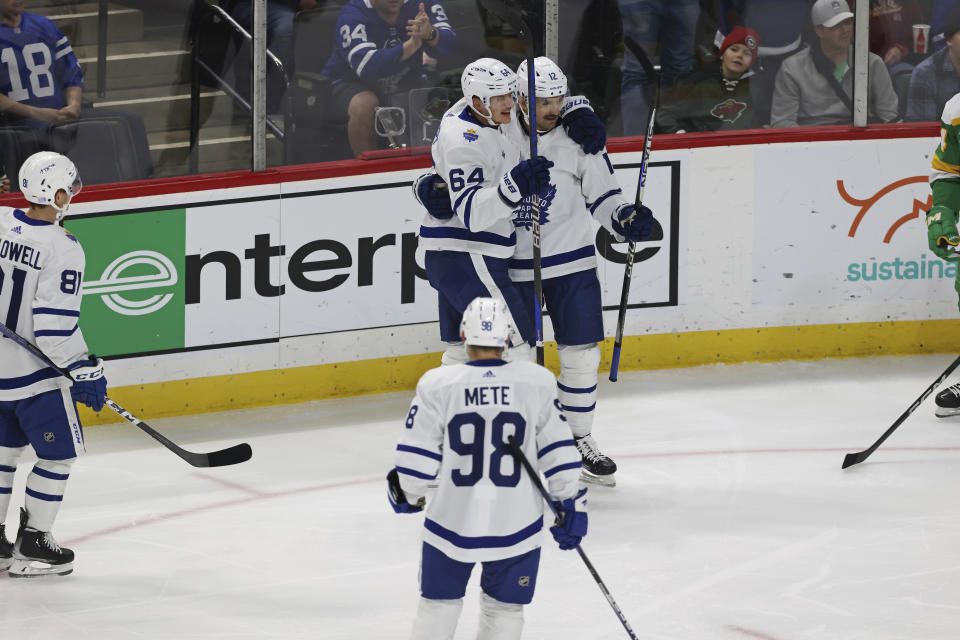 Toronto Maple Leafs centers Zach Aston-Reese (12) and David Kampf (64) celebrate after Aston-Reese scored a goal against the Minnesota Wild during the first period of an NHL hockey game Friday, Nov. 25, 2022, in St. Paul, Minn. (AP Photo/Stacy Bengs)