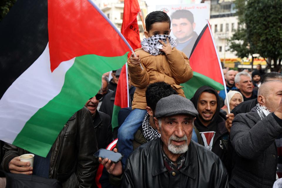 A Palestinian child waves a Palestinian flag during a protest after the killing of Hamas deputy leader Saleh al-Arouri in Lebanon in the occupied West Bank city of Ramallah on Jan. 3, 2024.