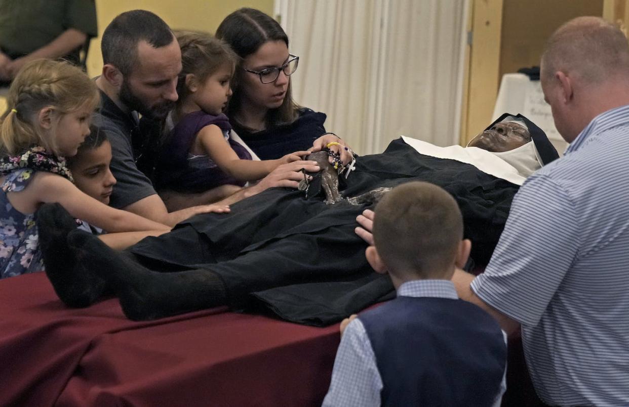 People pray over the body of Sister Wilhelmina Lancaster at the abbey of the Benedictines of Mary, Queen of Apostles, near Gower, Mo., in April 2023. <a href="https://newsroom.ap.org/detail/PicturesoftheWeek-NorthAmerica-PhotoGallery/d32f680364ec4c5b97171fe0ba54f042/photo?Query=sister%20lancaster&mediaType=photo&sortBy=&dateRange=Anytime&totalCount=45&currentItemNo=1" rel="nofollow noopener" target="_blank" data-ylk="slk:AP Photo/Charlie Riedel;elm:context_link;itc:0;sec:content-canvas" class="link ">AP Photo/Charlie Riedel</a>