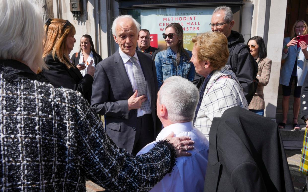 Chairman of the infected blood inquiry Sir Brian Langstaff with victims and campaigners outside Central Hall in Westminster