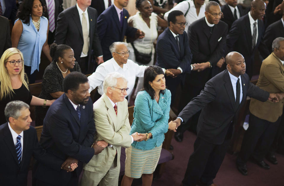 FILE - South Carolina Gov. Nikki Haley, center right, joins hands with Charleston Mayor Joseph Riley, left, and Sen. Tim Scott, R-S.C., right, at a memorial service at Morris Brown AME Church for the people killed during a prayer meeting inside the historic black church in Charleston, S.C., June 18, 2015. Scott has filed paperwork to enter the 2024 Republican presidential race. He'll be testing whether a more optimistic vision of America’s future can resonate with GOP voters who have elevated partisan brawlers in recent years. (AP Photo/David Goldman, File)