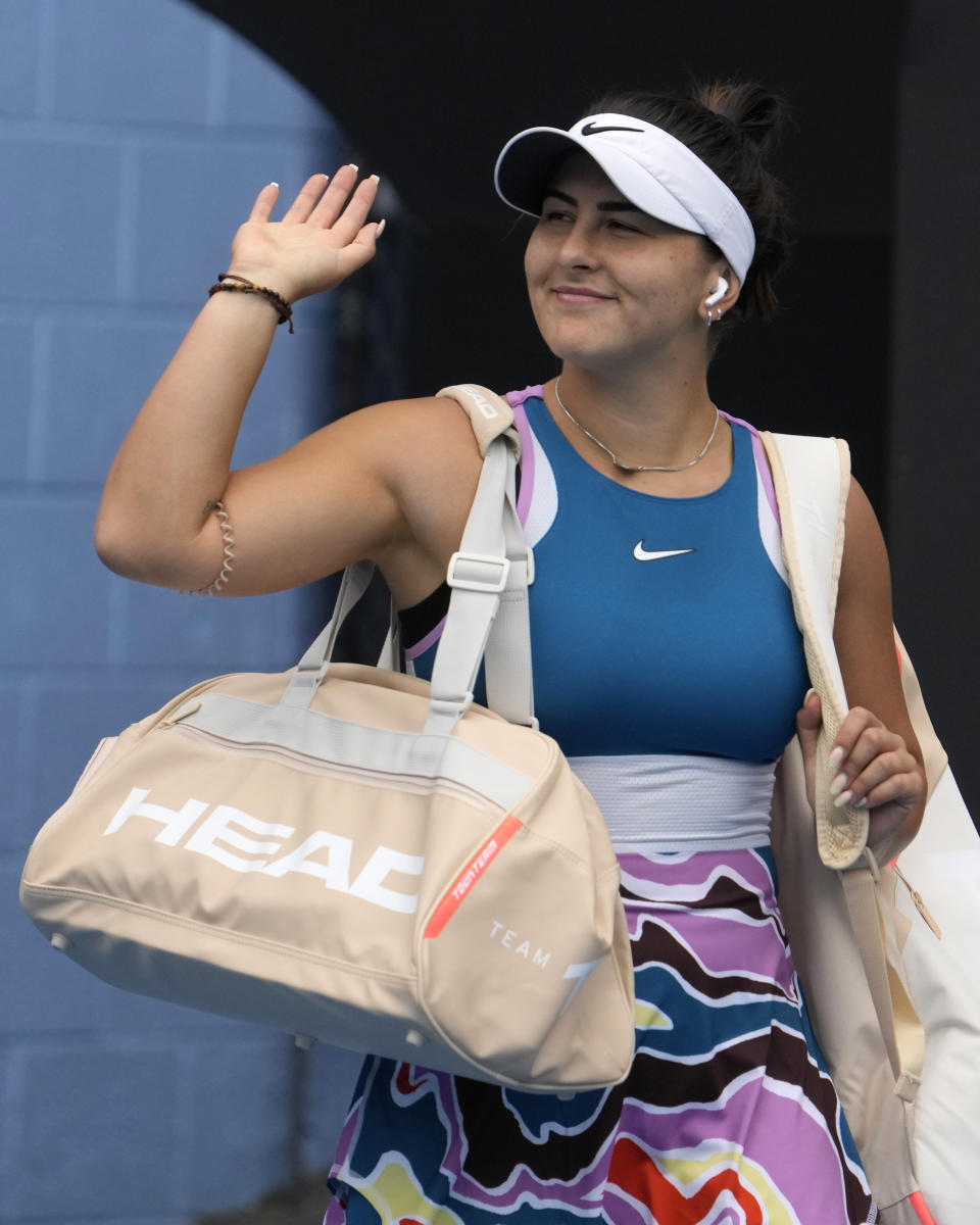 Bianca Andreescu of Canada waves as she walks onto the court ahead of her first round match against Marie Bouzkova of the Czech Republic at the Australian Open tennis championship in Melbourne, Australia, Monday, Jan. 16, 2023. (AP Photo/Ng Han Guan)