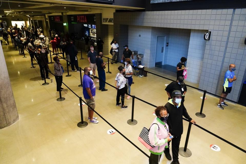 People wait in line to vote early at the State Farm Arena on Monday, Oct. 12, 2020, in Atlanta. (AP Photo/Brynn Anderson)