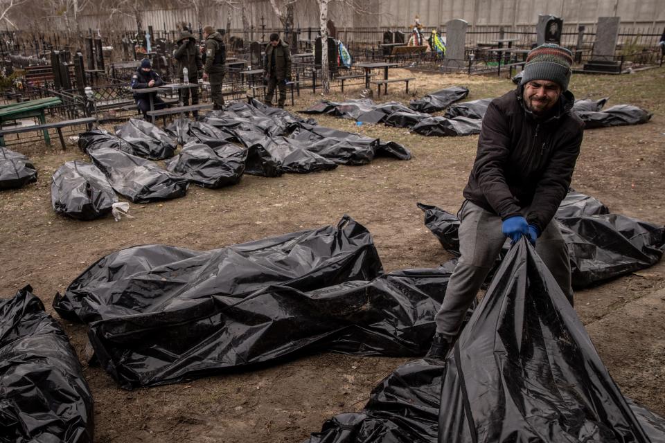 Policemen and forensic personnel catalog 58 bodies of civilians killed in and around Bucha before transport to the morgue at a cemetery on April 6 in Bucha, Ukraine.