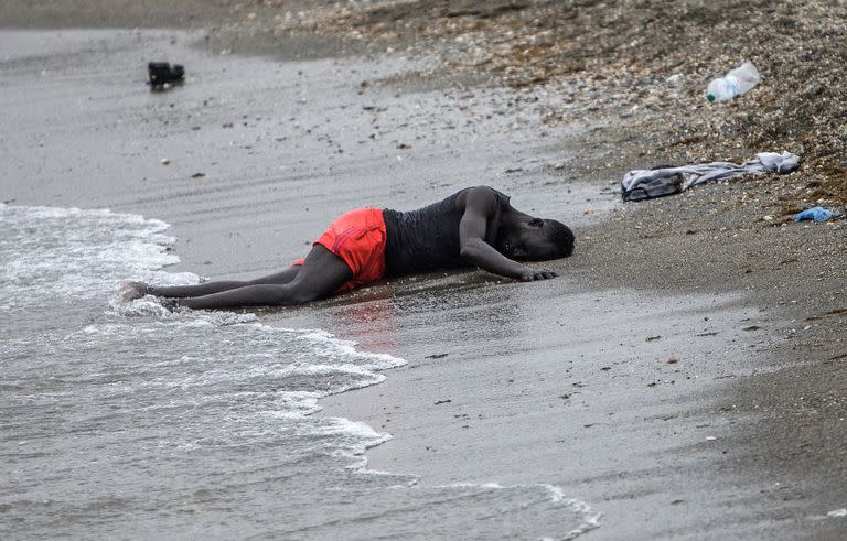 Un hombre yace en la playa en el enclave español de Ceuta en el norte de África después de nadar allí desde Marruecos el 18 de mayo 

