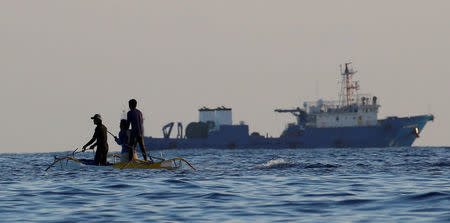 Filipino fishermen past a large Chinese vessel at the disputed Scarborough Shoal April 5, 2017. Picture taken April 5, 2017 REUTERS/Erik De Castro