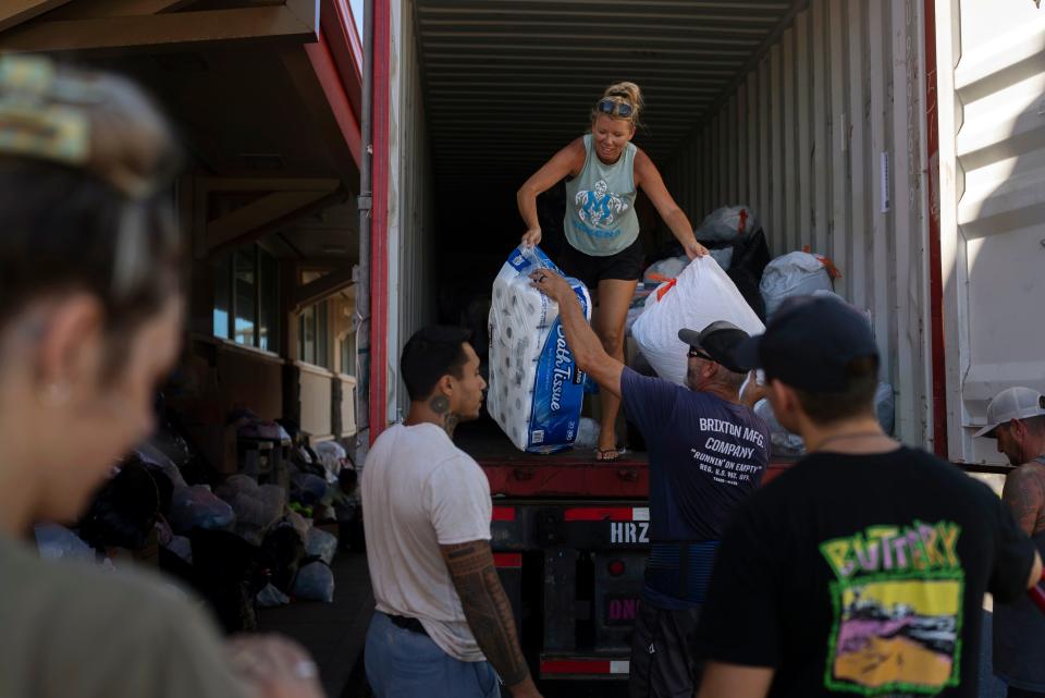 Volunteers unload donated goods at a food and supply distribution center in Lahaina, Hawaii, Thursday, Aug. 17, 2023. Long before a wildfire blasted through the island of Maui the week before, there was tension between Hawaii's longtime residents and the visitors some islanders resent for turning their beaches, mountains, and communities into playgrounds. But that tension is building in the aftermath of the deadliest U.S. wildfire in more than a century.