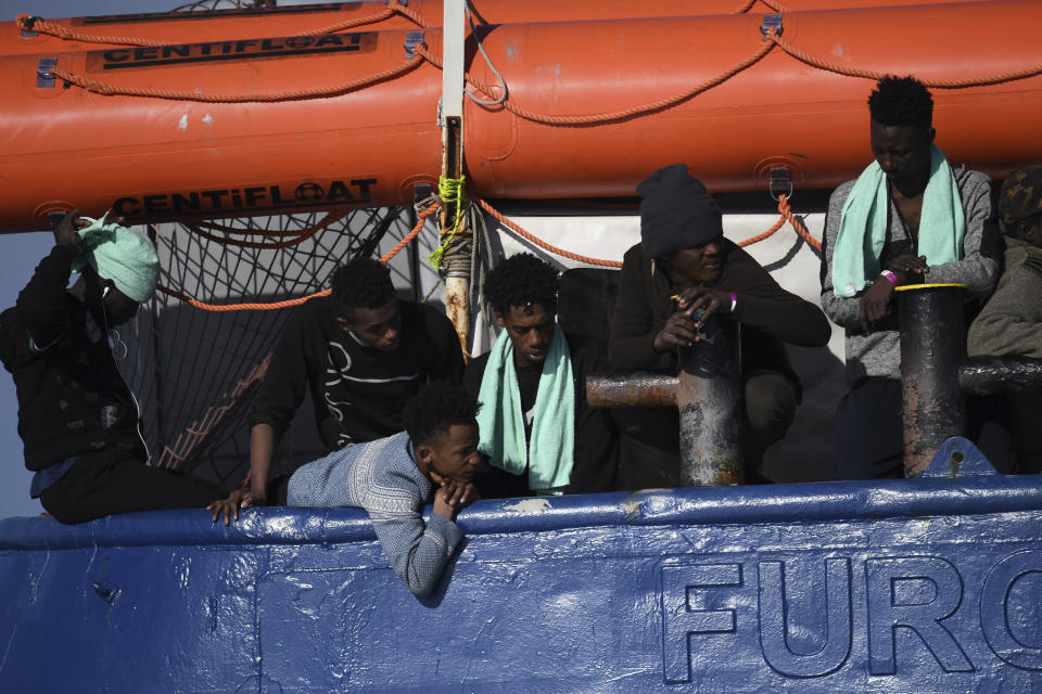 Migrants wait aboard the German humanitarian group's rescue boat Sea Watch 3, off the coast of Syracuse, Italy, Sunday, Jan. 27, 2019. The Italian coast guard is bringing socks, shoes, bread and fruit to 47 migrants who have been stranded at sea for nine days aboard a German ship. (AP Photo/Salvatore Cavalli)