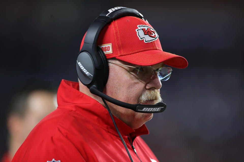 Andy Reid looks on during the Super Bowl while wearing a headset and red Chiefs hat.