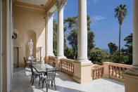 <p>Palm trees stand beyond columns on a terrace. A huge, wood-panelled library holds 3,000 books on flora and naturalism. </p>