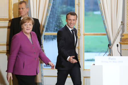 French President Emmanuel Macron (R) and German Chancellor Angela Merkel give a joint press conference at the Eylsee presidential Palace in Paris, France March 16, 2018. Ludovic Marin/Pool via REUTERS