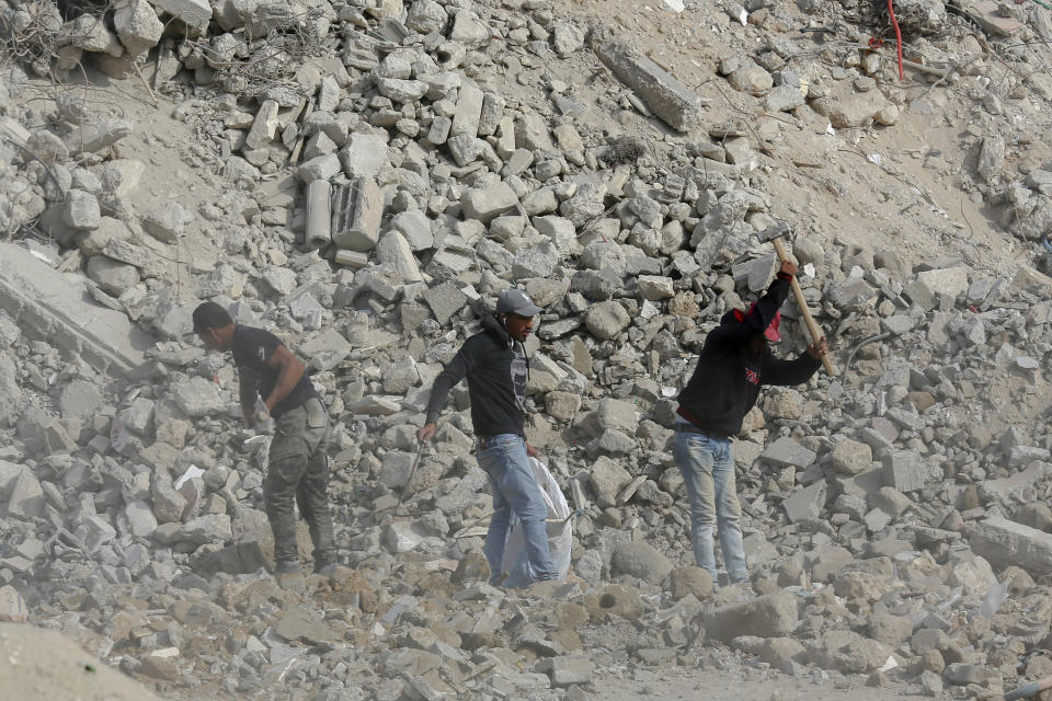 Palestinian workers salvage metal to sell and collect rubble from destroyed buildings to make recycled concrete bricks to be used in the reconstruction of war damaged buildings, east of Gaza City, Nov. 24, 2021. The Gaza Strip has few jobs, little electricity and almost no natural resources. But after four bruising wars with Israel in just over a decade, it has lots of rubble. Local businesses are now finding ways to cash in on the chunks of smashed concrete, bricks and debris left behind by years of conflict. (AP Photo/Adel Hana)